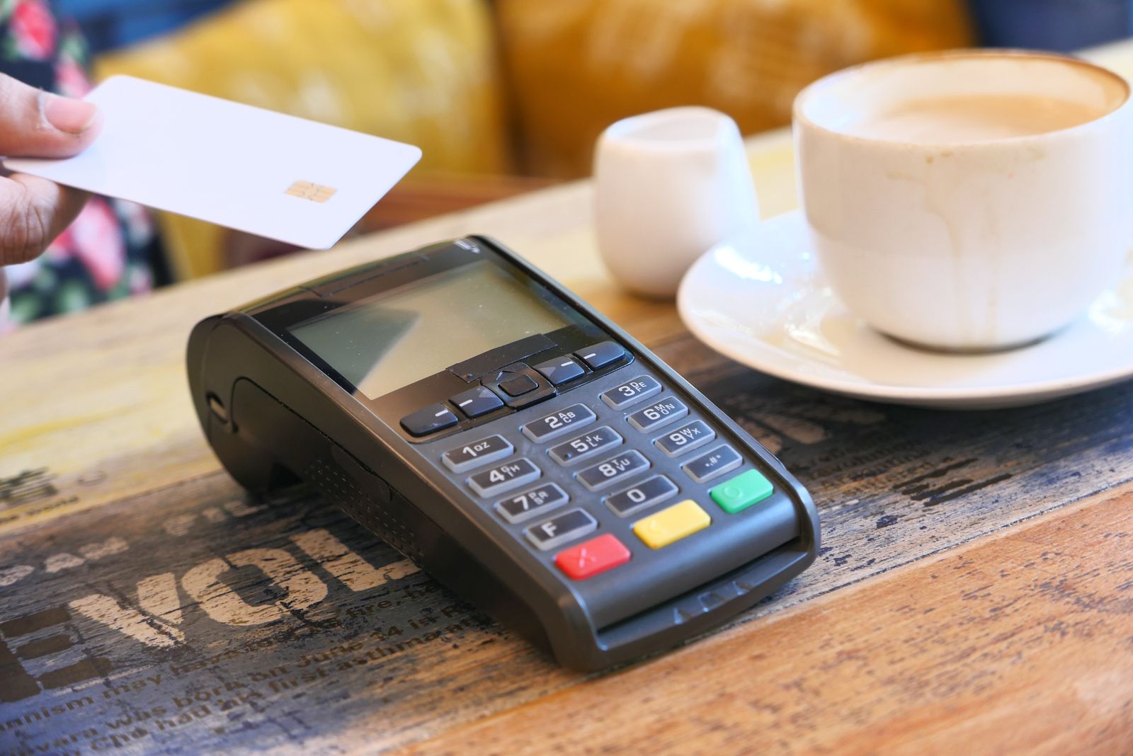 Paiement sans contact par carte bancaire sur un terminal dans un café