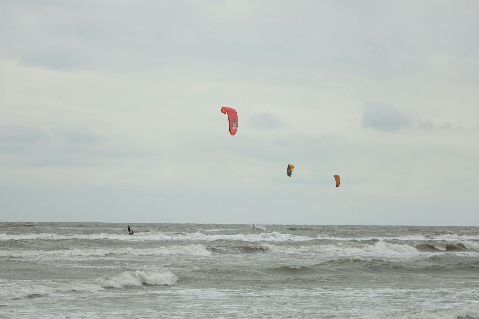 Kitesurfeurs glissant sur les vagues de l'océan avec leurs ailes colorées