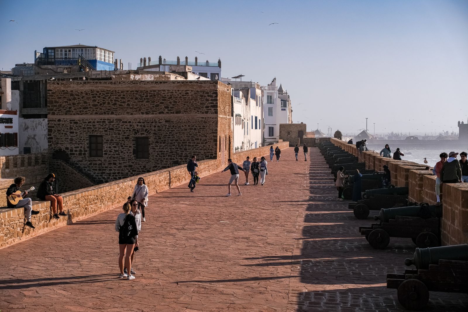 Promeneurs sur les remparts et les canons de la Skala à Essaouira