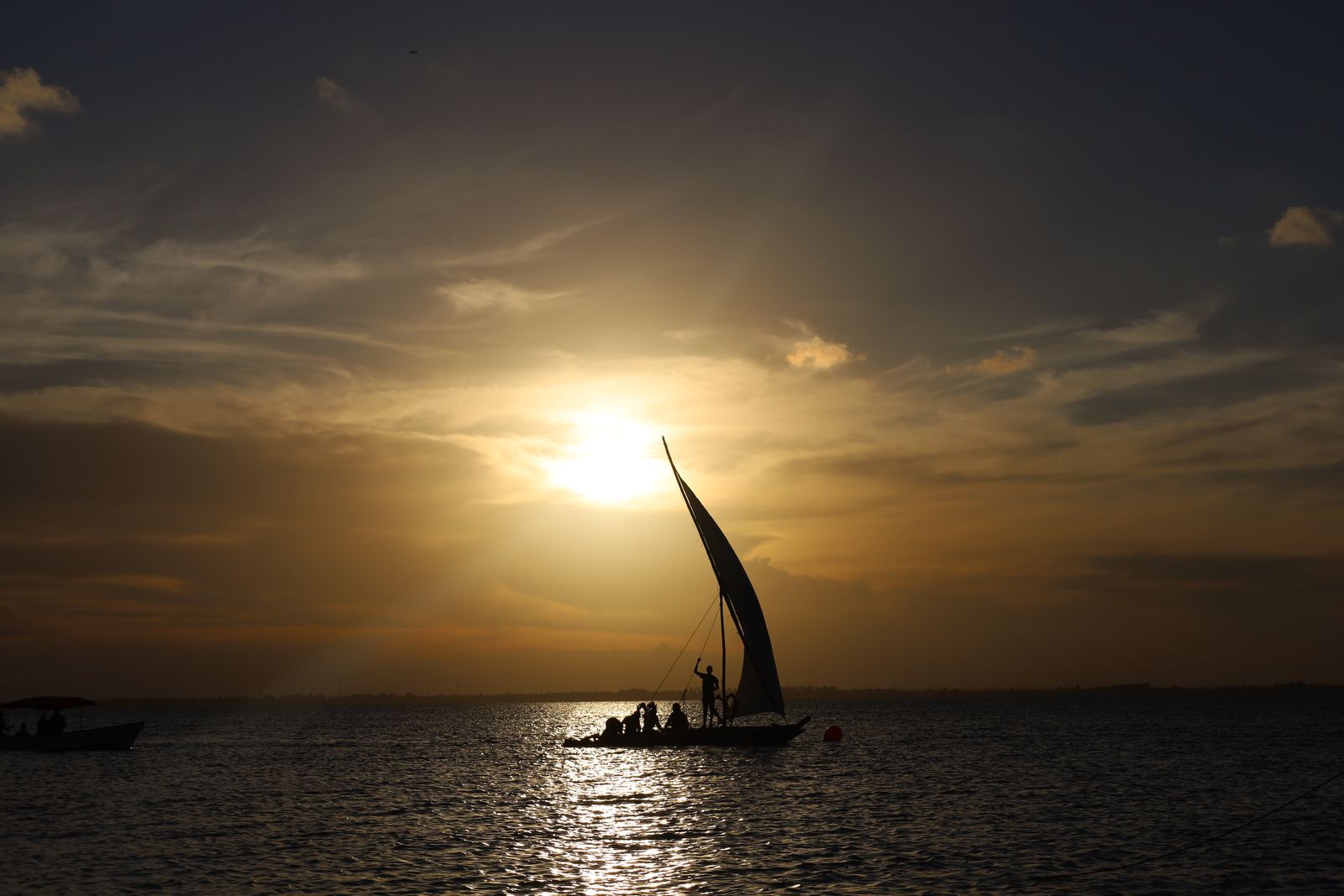 Dhow traditionnel à voile au coucher du soleil au large de Zanzibar