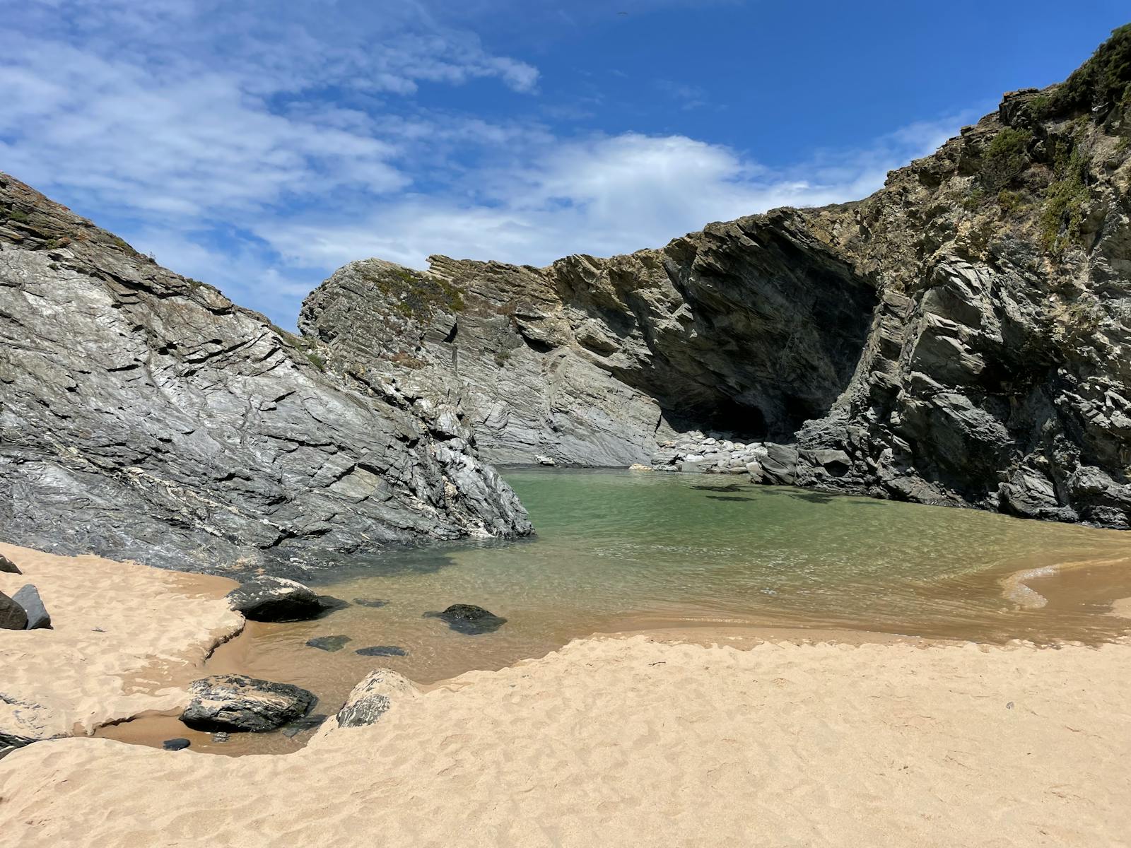 Crique isolée aux eaux claires entourée de falaises rocheuses, sans foule
