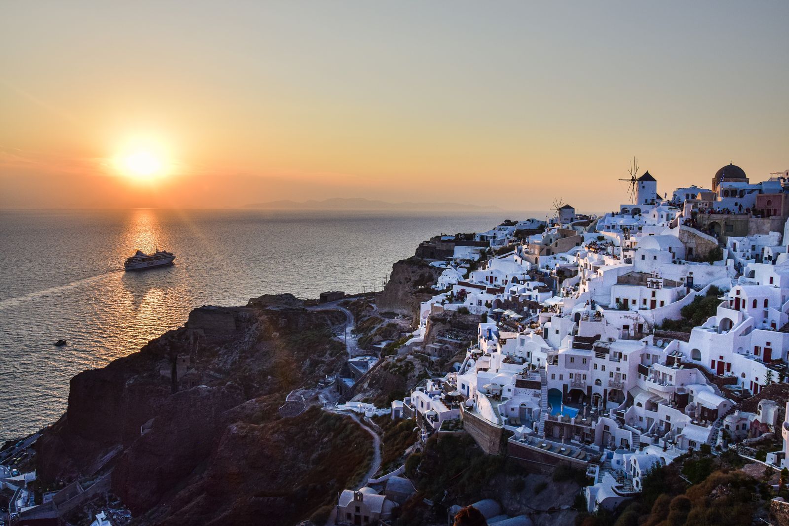 Village blanc de Santorin au coucher du soleil surplombant la mer Égée