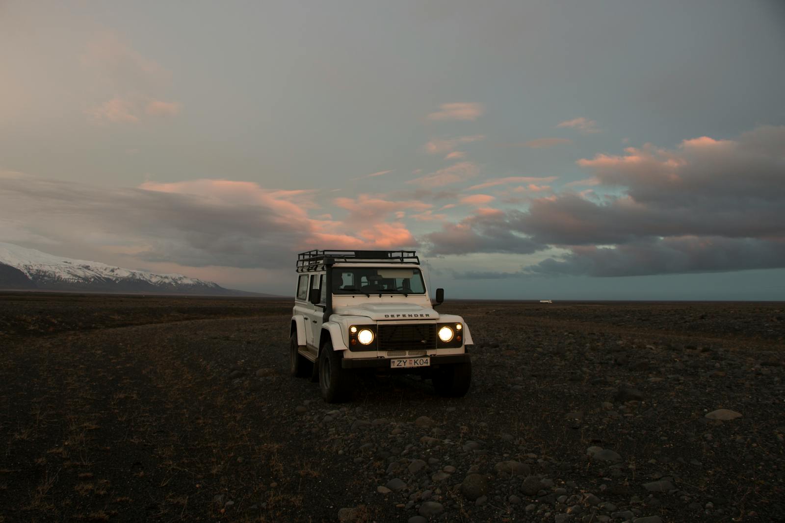 Land Rover Defender 4×4 sur un terrain volcanique islandais au crépuscule