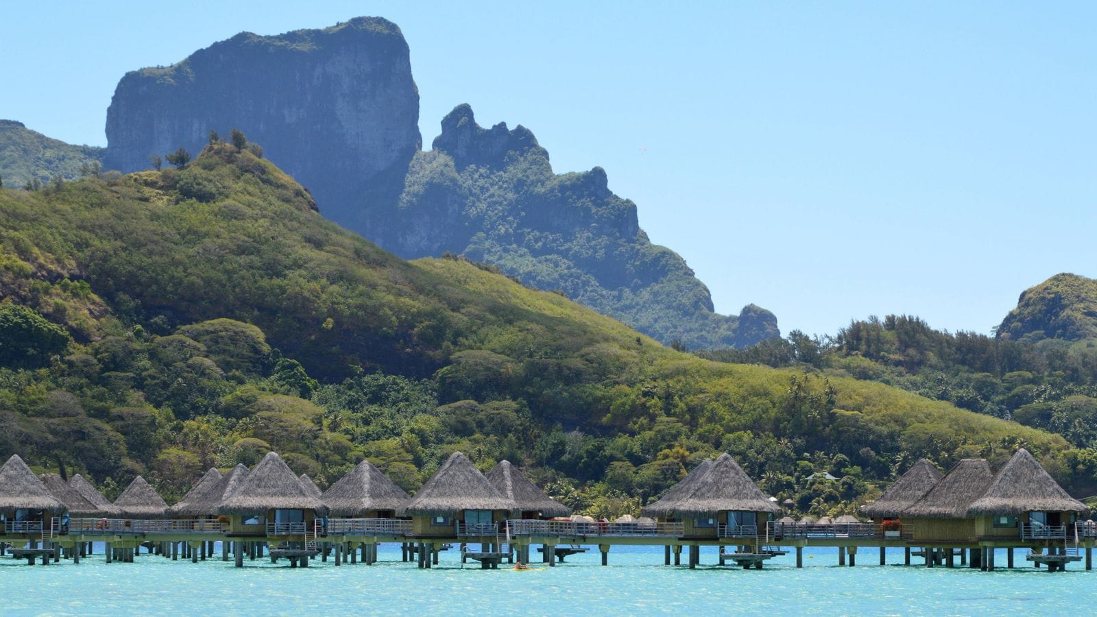 Bungalows sur pilotis et collines verdoyantes de Bora Bora en Polynésie française