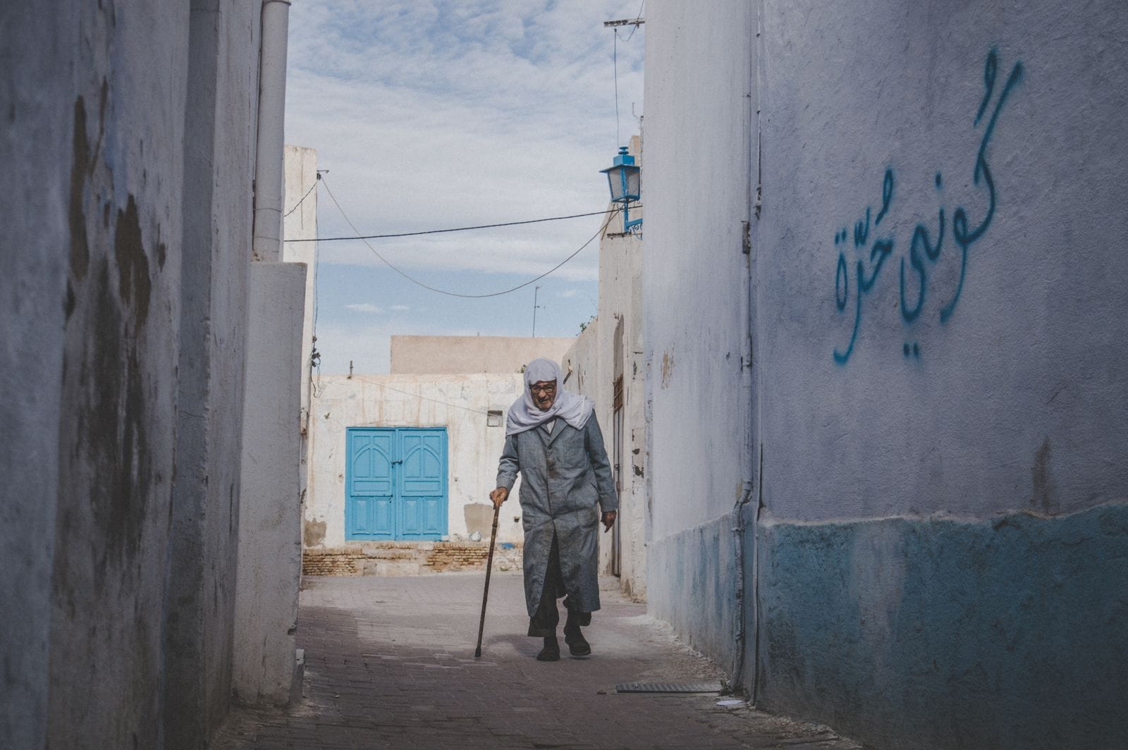 Homme âgé dans une ruelle de la médina tunisienne, scène de vie locale