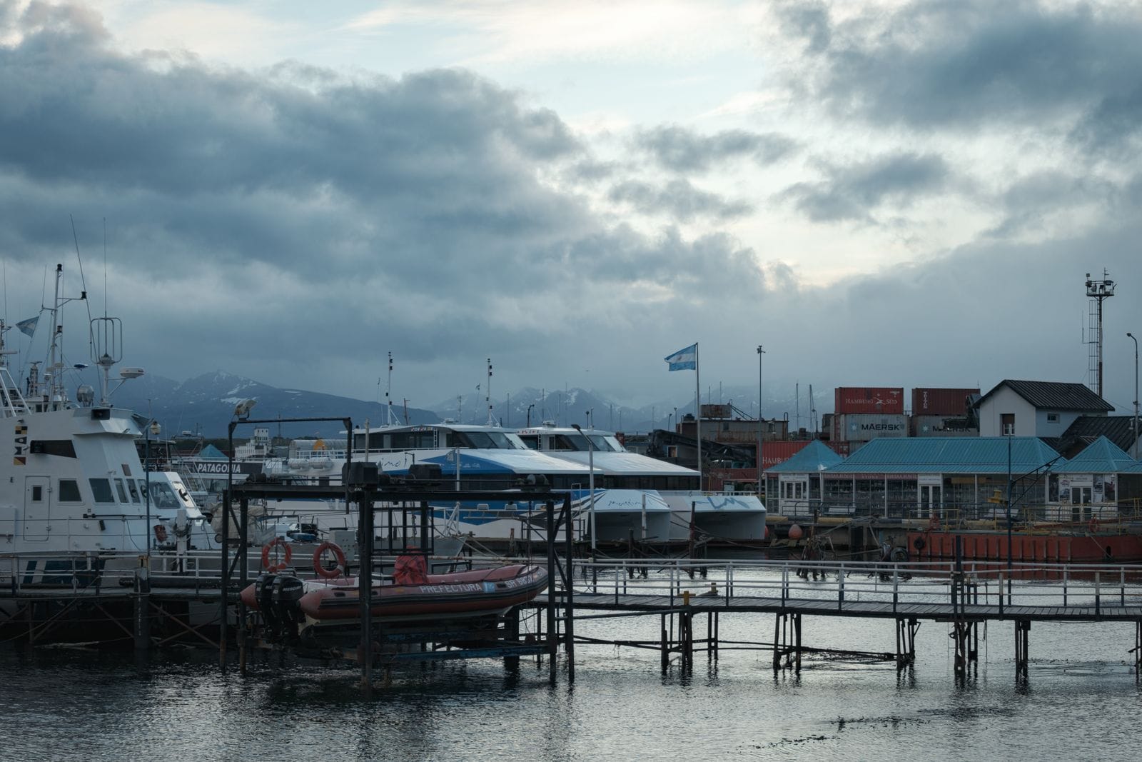 Port d'Ushuaia en Terre de Feu argentine avec bateau Patagonia et montagnes enneigées