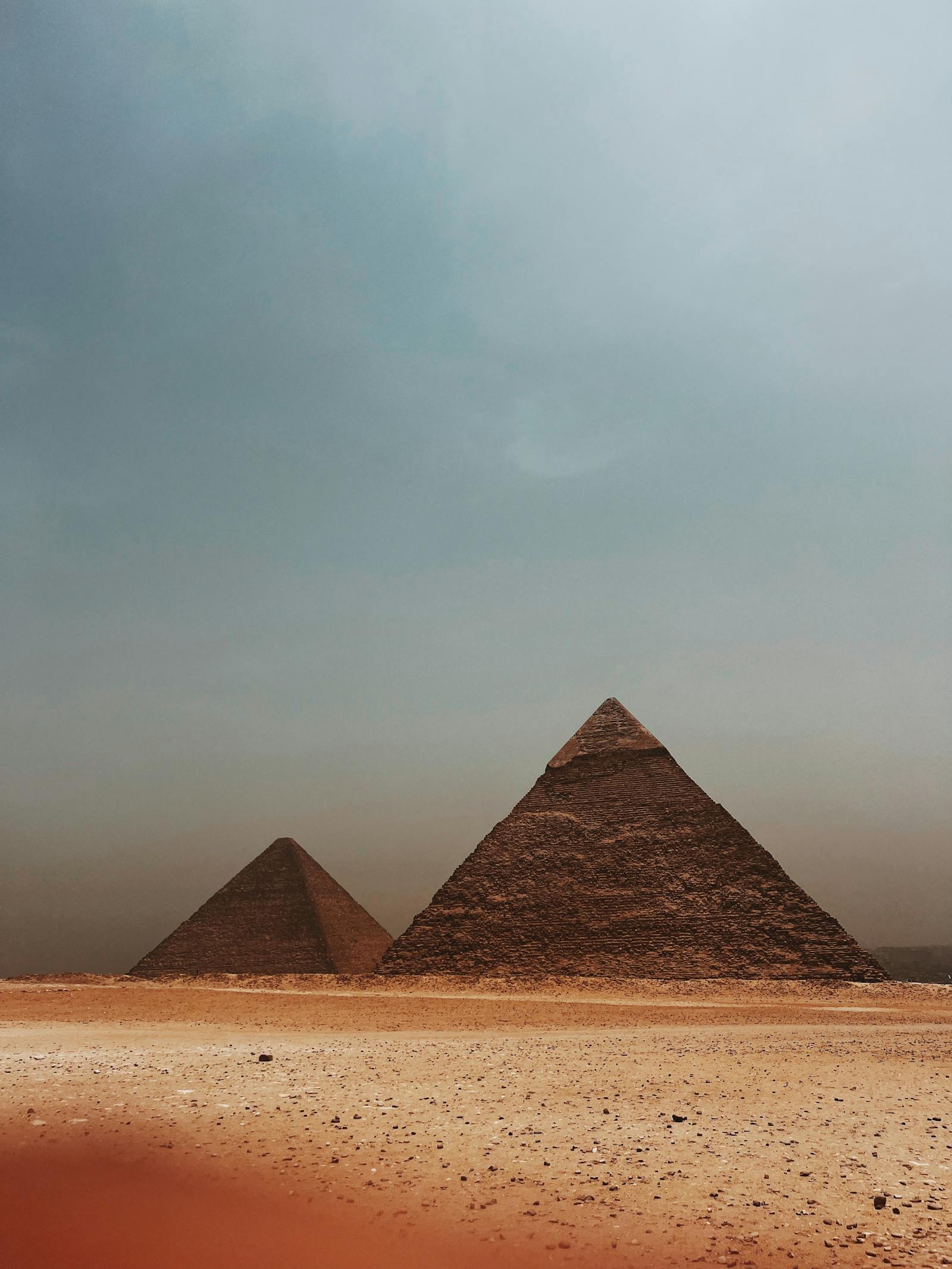 Pyramides majestueuses de Gizeh sous un vaste ciel nuageux