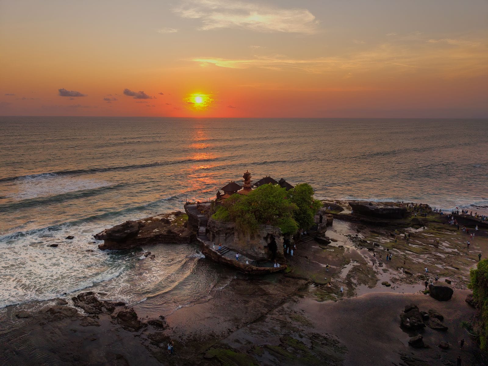 Coucher de soleil sur le temple de Tanah Lot à Bali, reflets sur l'océan