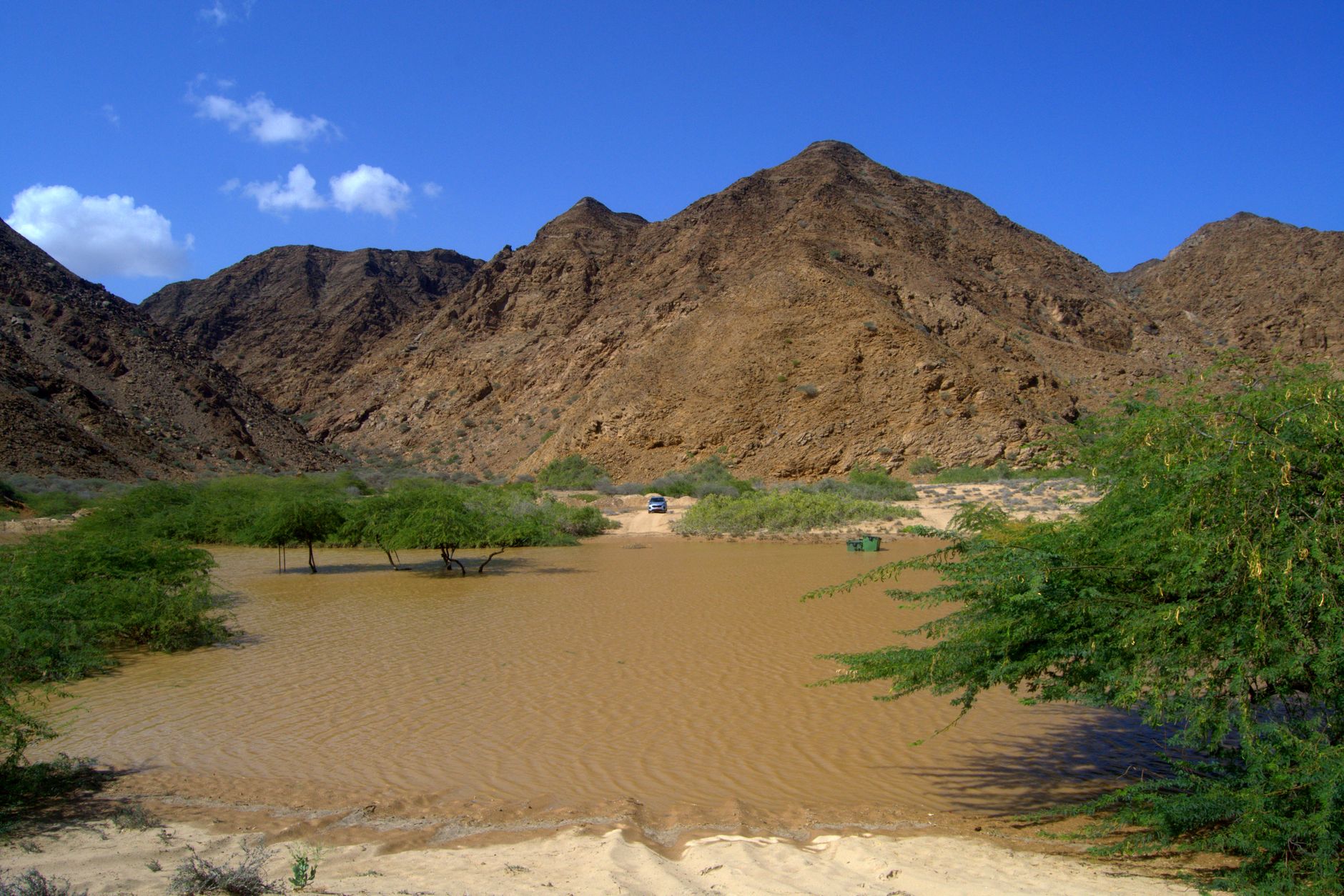 Bassin naturel entouré de montagnes arides à As Sifah, Oman