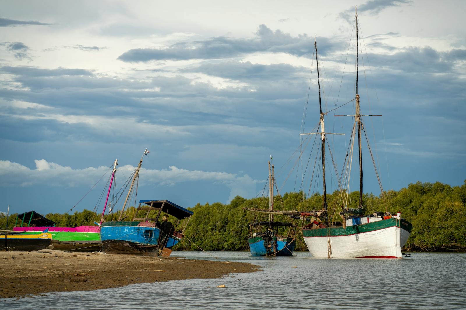 Barques de pêcheurs colorées sur une plage de sable à Madagascar sous un ciel spectaculaire