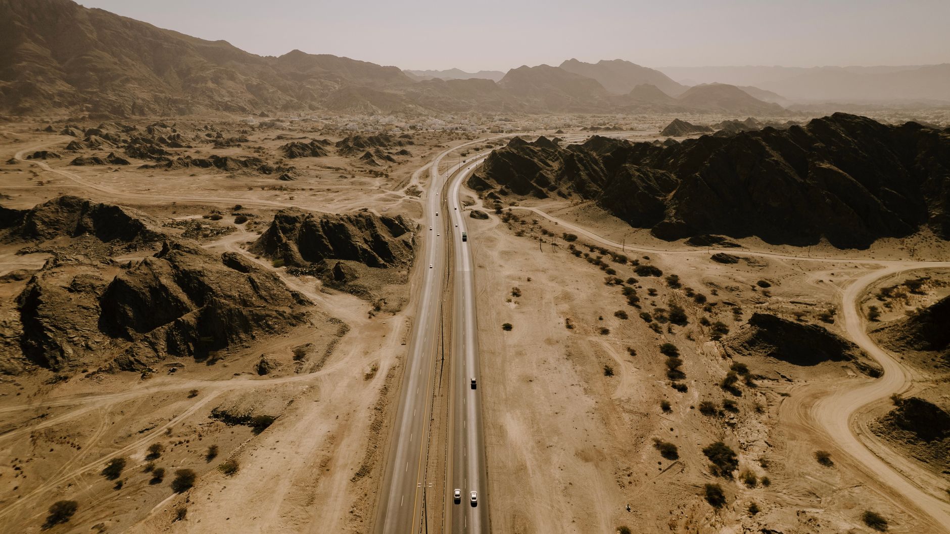 Route désertique serpentant entre les reliefs rocheux, vue aérienne, Oman