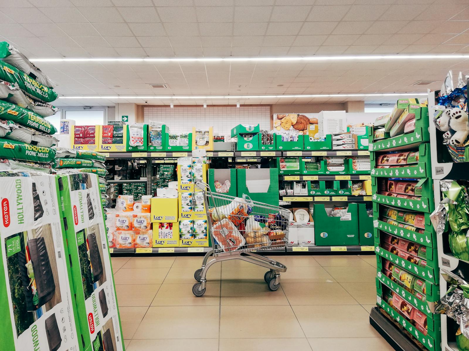 Chariot de courses dans une allée de supermarché bien achalandée, comme chez les enseignes discount Bonus et Krónan