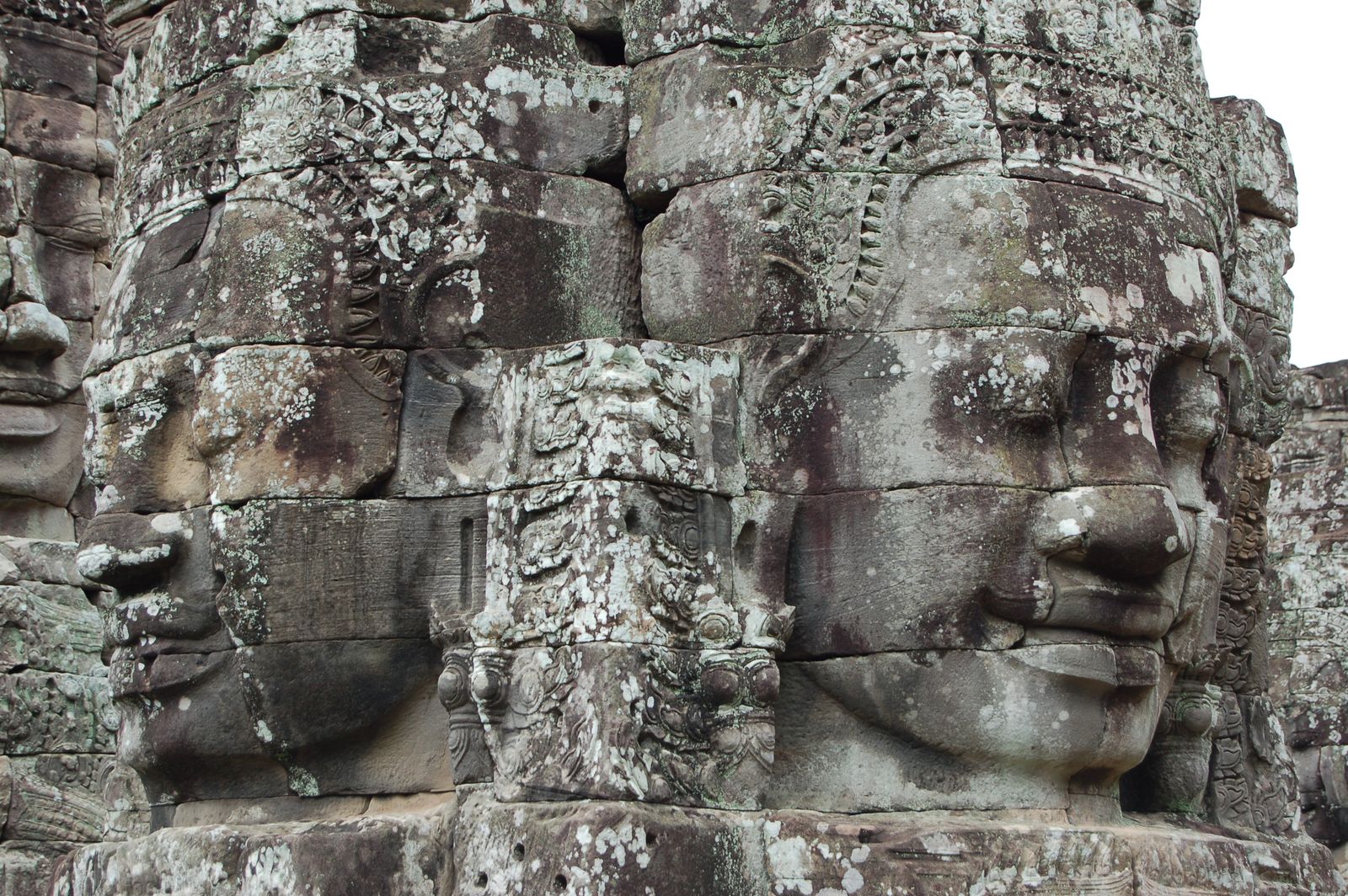 Visages de pierre souriants sculptés sur les tours du temple Bayon à Angkor Thom
