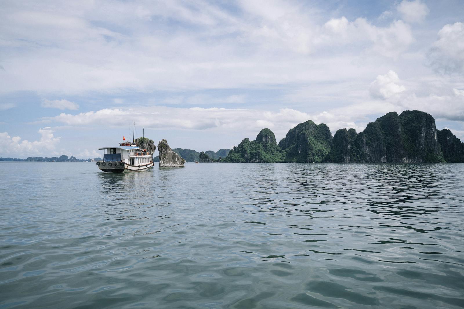 Jonque naviguant entre les pitons karstiques de la baie d'Halong