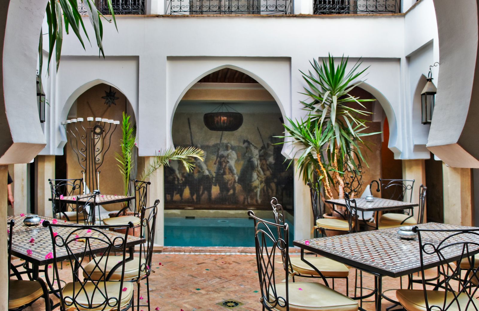 Patio de riad marocain avec table ornée et zelliges, cœur architectural des maisons de la médina