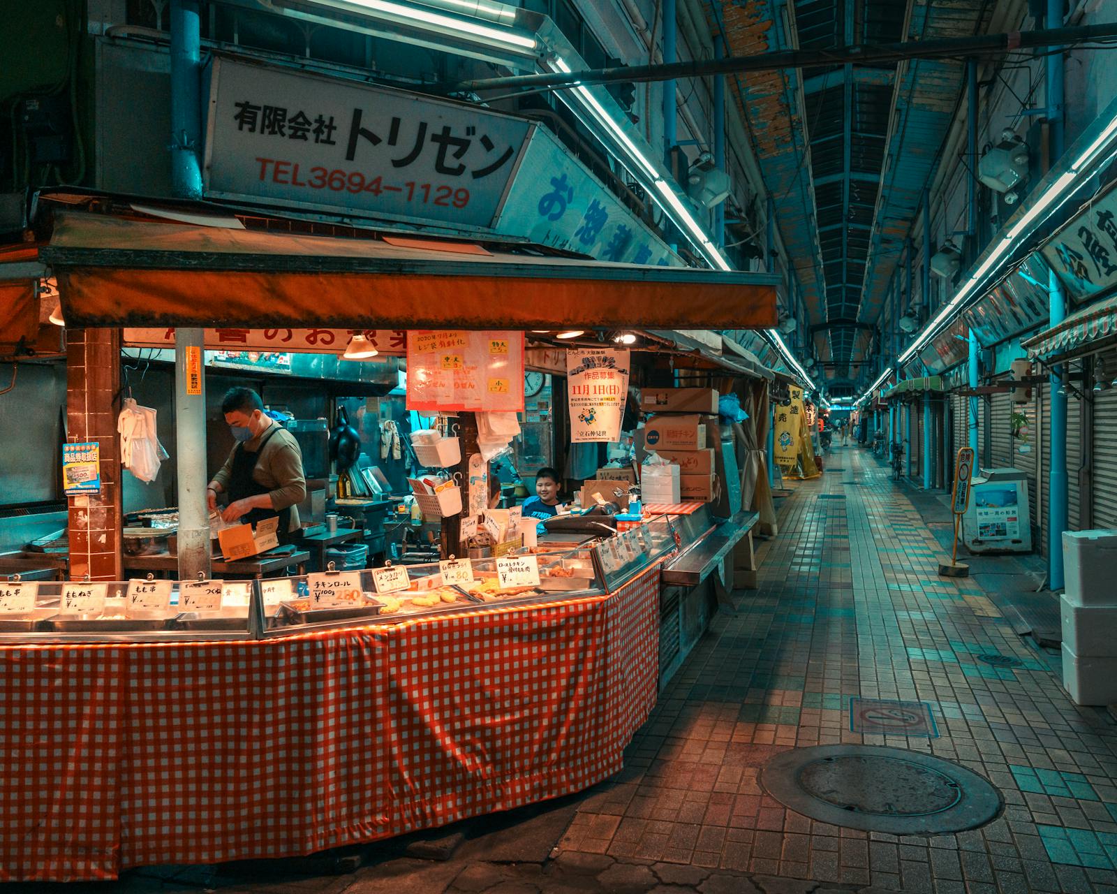 Stand de street food japonais au crépuscule avec vendeur sous les lampions